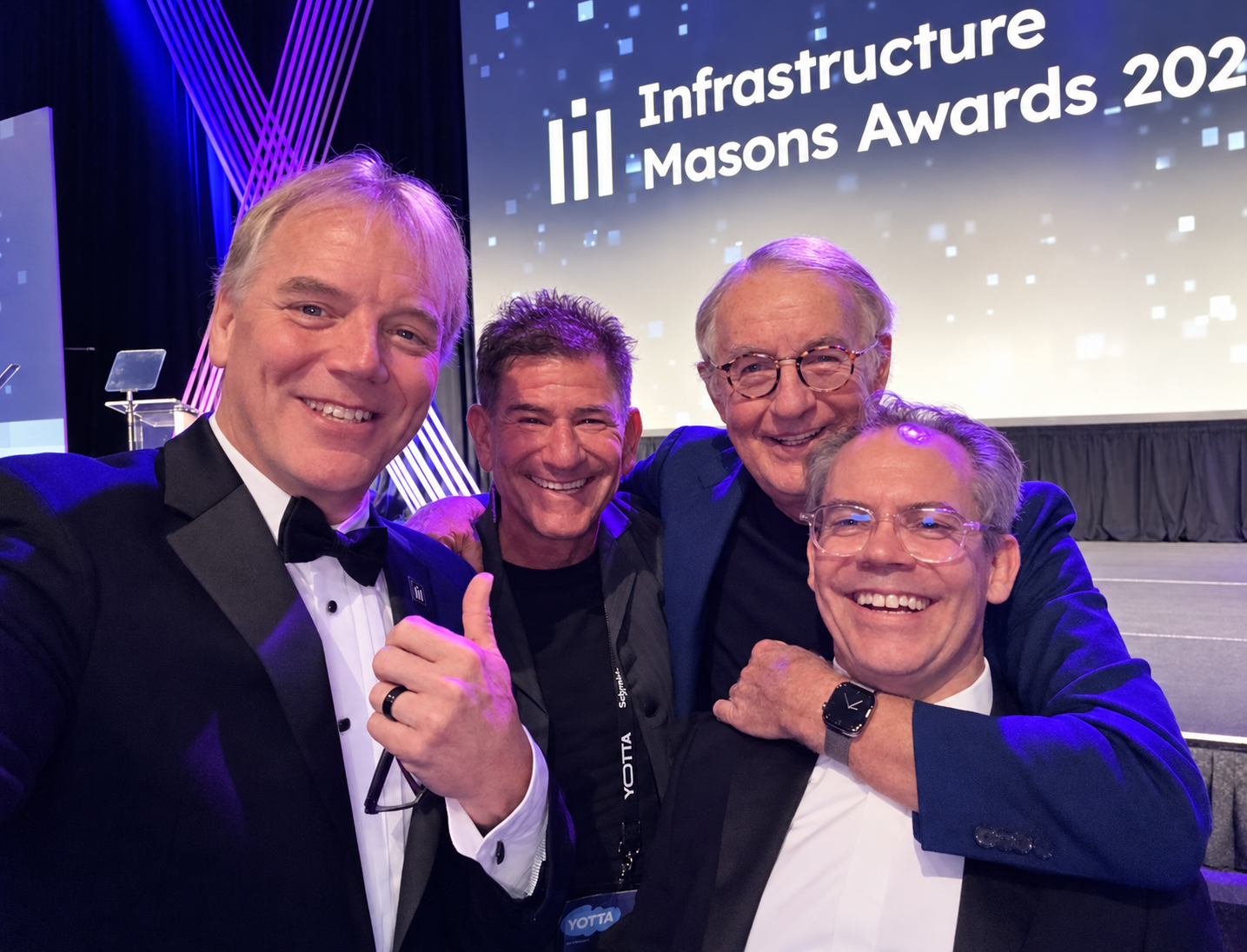 Dean Nelson, Tony Greenberg, Peter Gross and George Rockett together at the illuminated Infrastructure Masons Awards backdrop